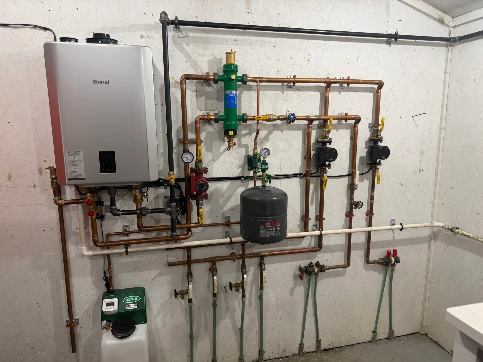 Rinnai tankless heater with copper piping, backflow preventer, expansion tank, and isolation valves