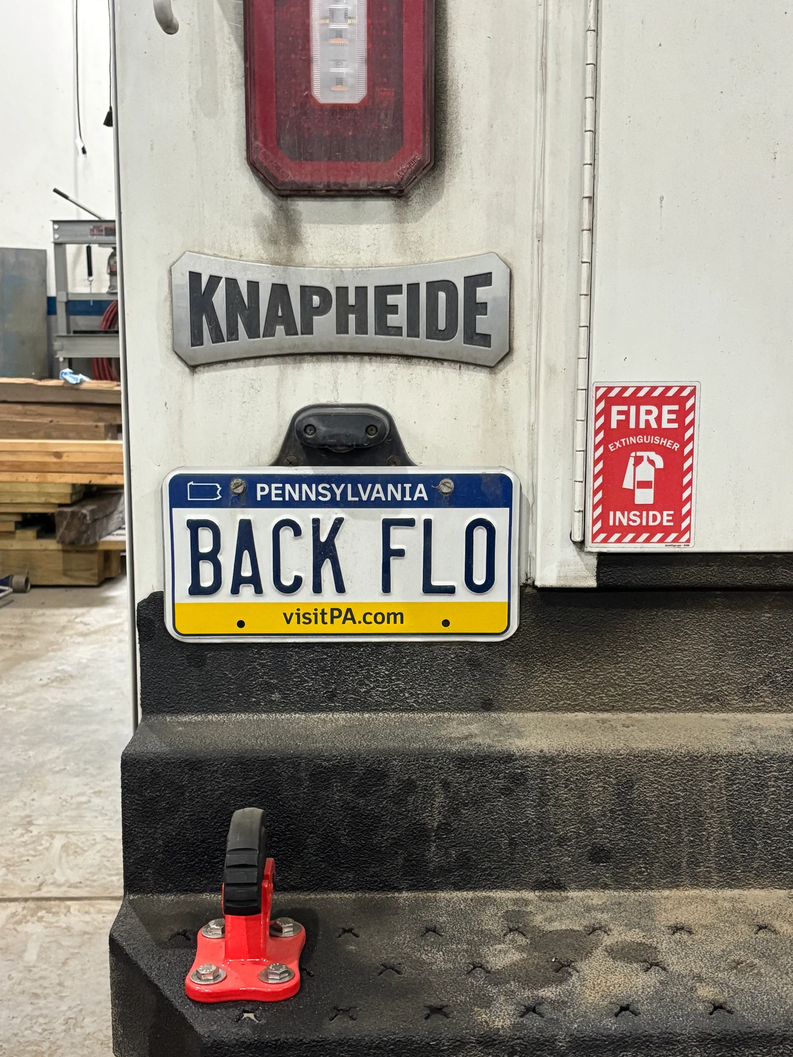 Knapheide backflow preventer with red manual valve mounted on vehicle bumper
