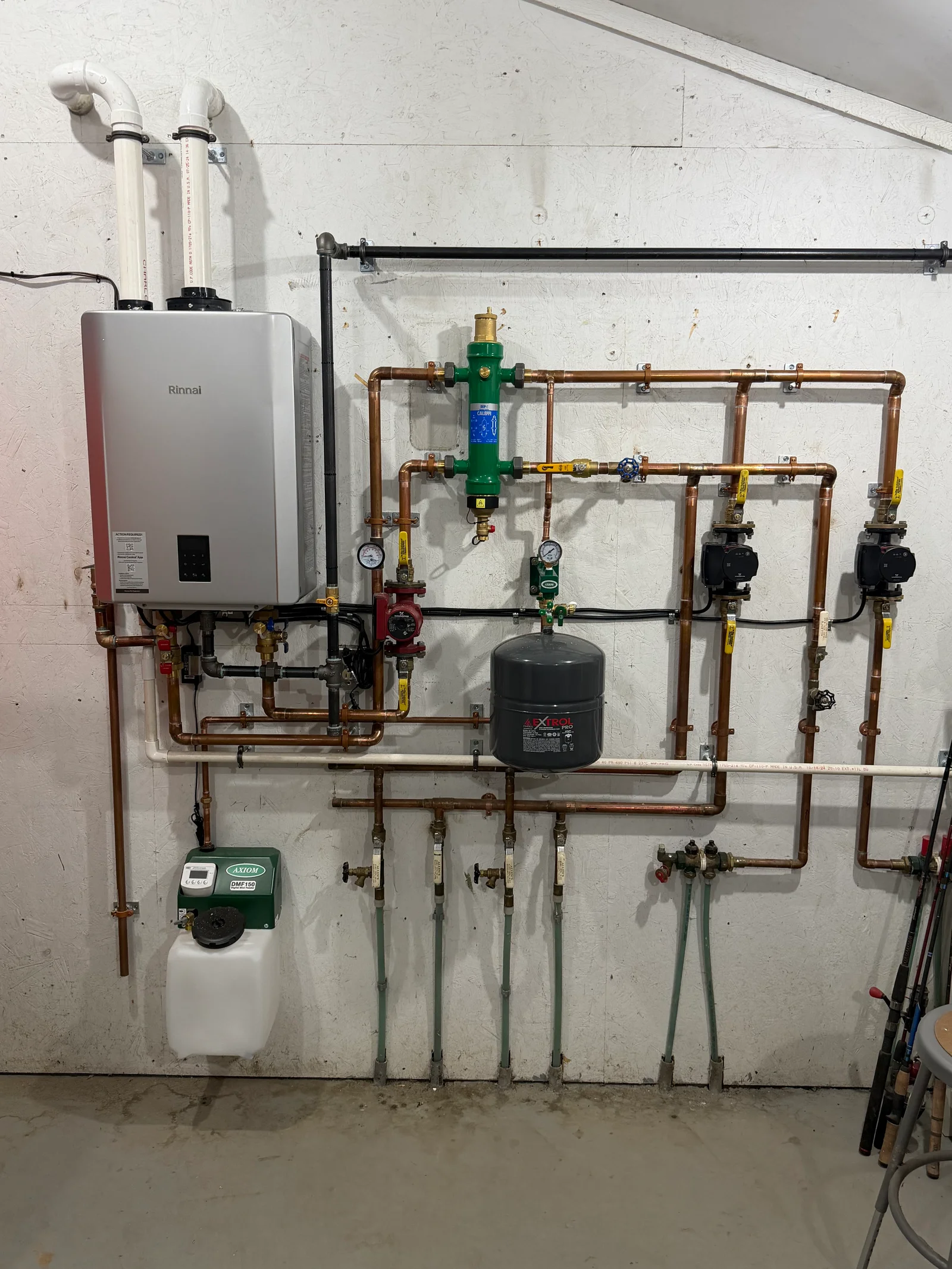 Rinnai tankless heater with copper backflow prevention piping, expansion tank, and check valves